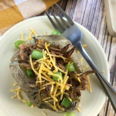 This pulled pork baked potato recipe will satisfy your craving for BBQ right at home. Pulled pork directions for the slow cooker and Instant Pot are included!
